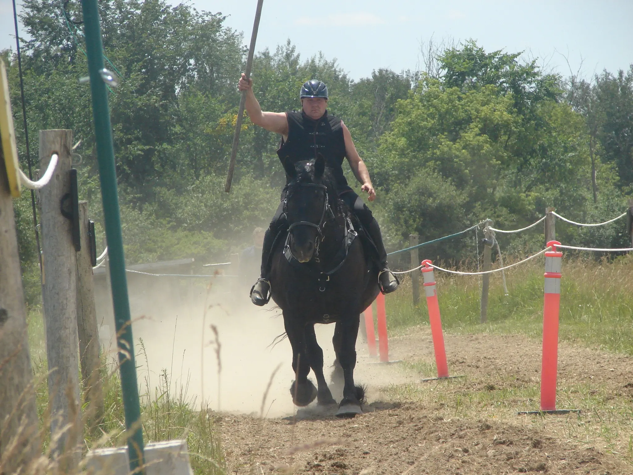 Black horse with rider charging toward the camera