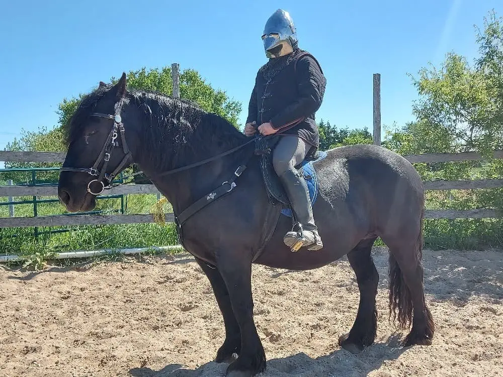 Ivan in his helmet sitting on a big black horse